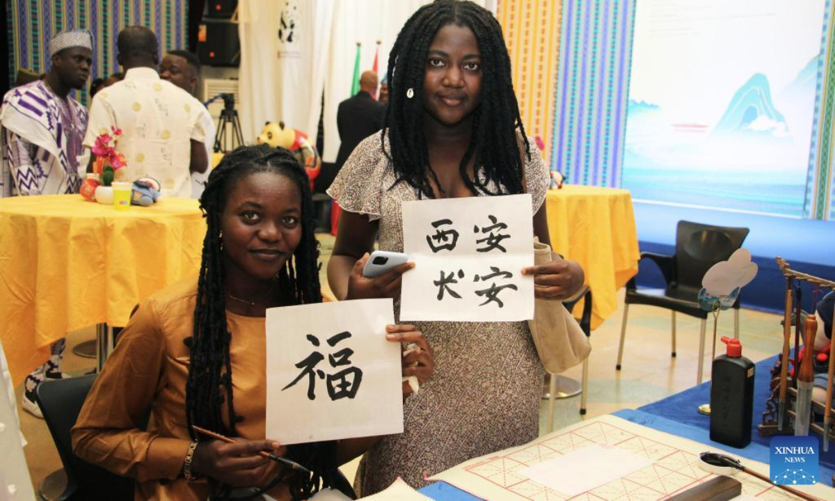 People experience traditional Chinese calligraphy during a cultural event at the Chinese Cultural Center in Cotonou, Benin's economic capital, July 29, 2025. The event was held here on Tuesday night, offering the Beninese public a deep dive into the heritage of Xi'an, one of China's most historic cities. (Photo by Seraphin Zounyekpe/Xinhua)