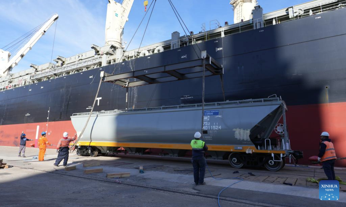 Workers unload a Chinese-made meter-gauge railway grain wagon at a port in Buenos Aires, Argentina, July 30, 2025. A total of 90 Chinese-made meter-gauge railway grain wagons arrived here on Tuesday, which will all be put into an Argentina's railway network to undertake soybean and corn transportation. (Xinhua/Zhang Duo)