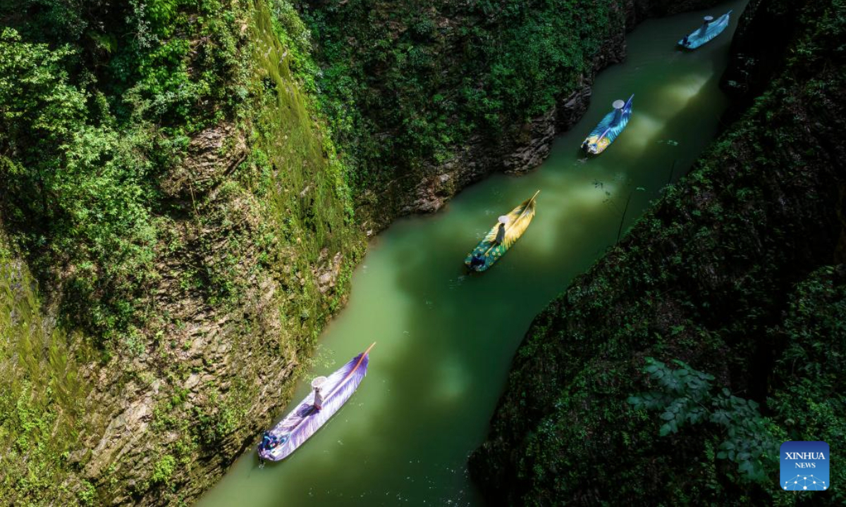 An aerial drone photo taken on July 9, 2025 shows tourists taking boats enjoying the view of Pingshan canyon in Hefeng County, Enshi Tujia and Miao Autonomous Prefecture, central China's Hubei Province. The unique canyon landscape and limpid water make the Pingshan Canyon an attractive destination for tourists. (Photo by Zheng Jiayu/Xinhua)