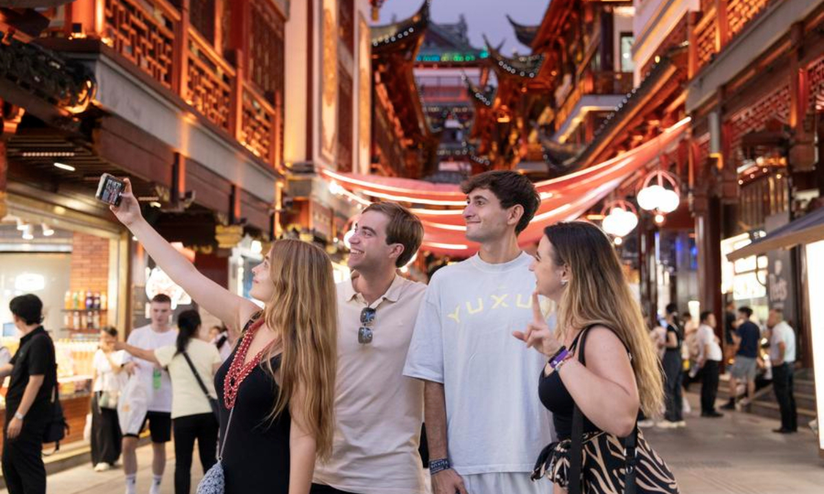 Tourists from Spain take a selfie at Yuyuan Garden Mall in Shanghai, east China, July 21, 2025. (Photo by Zhang Yue/Xinhua)