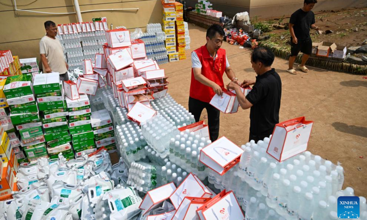 A volunteer delivers supplies to a villager in Liudaogou Village in Liudaohe Town, Xinglong County of north China's Hebei Province, Aug. 1, 2025. Affected by heavy rainfall, some roads and houses were damaged in several villages in Liudaohe Town. In recent days, local authorities have actively organized efforts to carry out relief operations to restore roads, power supply, and communication facilities, along with environmental disinfection measures. (Photo by Wang Liqun/Xinhua)