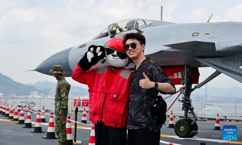 A visitor poses for photos on the aircraft carrier Shandong in Hong Kong, south China, July 5, 2025. Hong Kong celebrated the 28th anniversary of its return to the motherland with a significant visit from a fleet of the Chinese People's Liberation Army Navy, led by China's first homegrown aircraft carrier Shandong. Since November 2024, the Chinese People's Liberation Army Navy has made three visits to Hong Kong, deploying a range of vessels, including aircraft carriers, amphibious assault ships, and missile destroyers. (Photo: Xinhua)