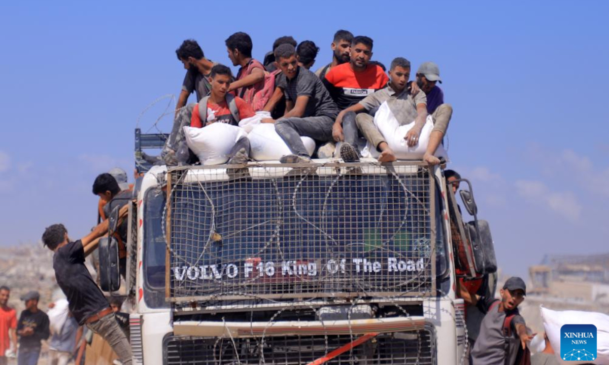 Palestinians transfer humanitarian aid in Beit Lahia, northern Gaza Strip, on Aug. 1, 2025. (Photo by Rizek Abdeljawad/Xinhua)