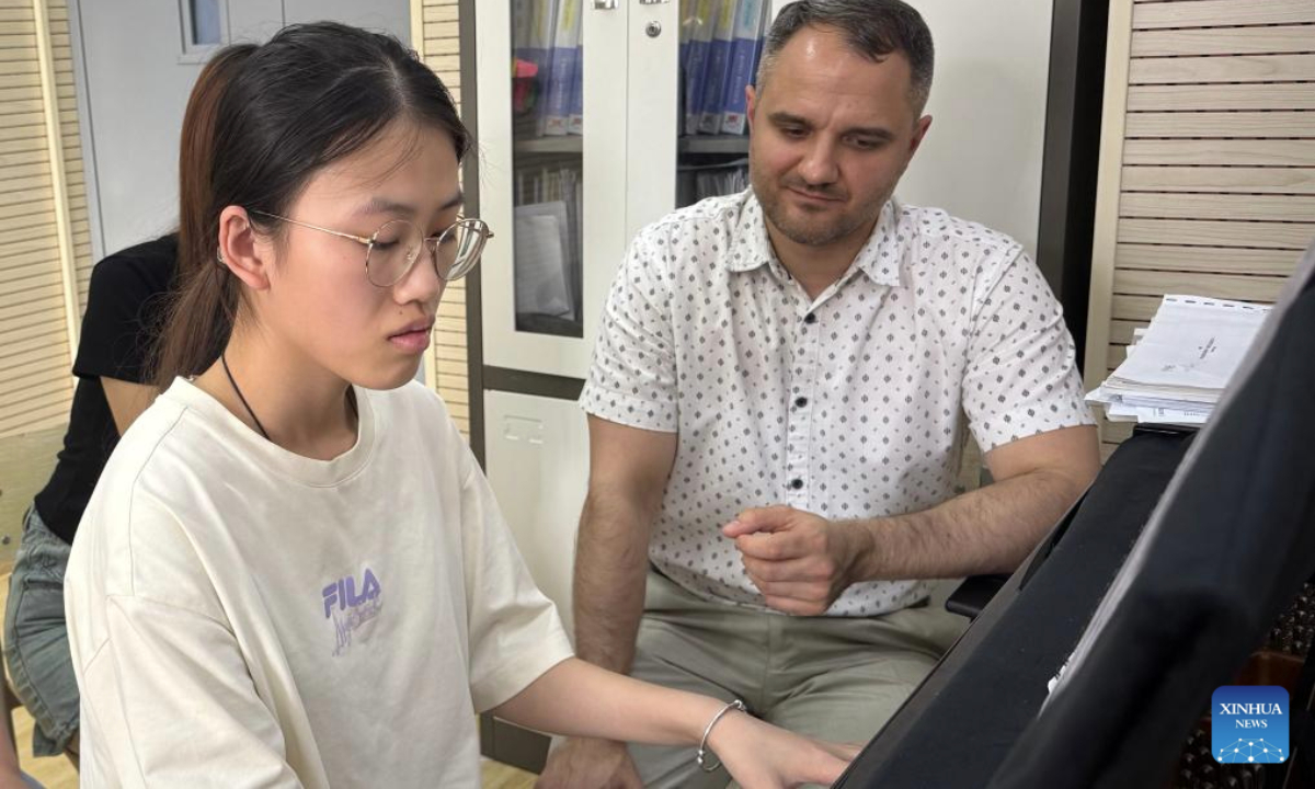 Ostapenko Anton Gennadievich (R) instructs his students to play the piano in Harbin, northeast China's Heilongjiang Province, June 18, 2025. (Xinhua/Yang Siqi)