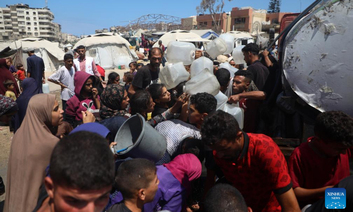 Displaced Palestinians fetch water at a temporary shelter in Gaza City, on Aug. 1, 2025. (Photo by Rizek Abdeljawad/Xinhua)