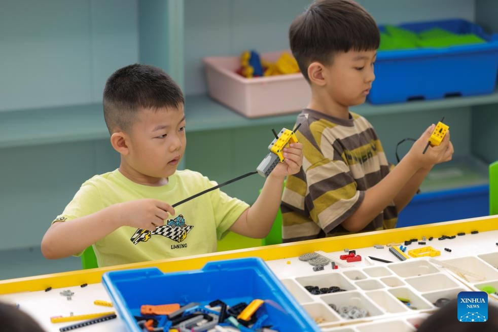 Children assemble robot models at a training institution in Zaozhuang City, east China's Shandong Province, July 5, 2025. (Photo: Xinhua)