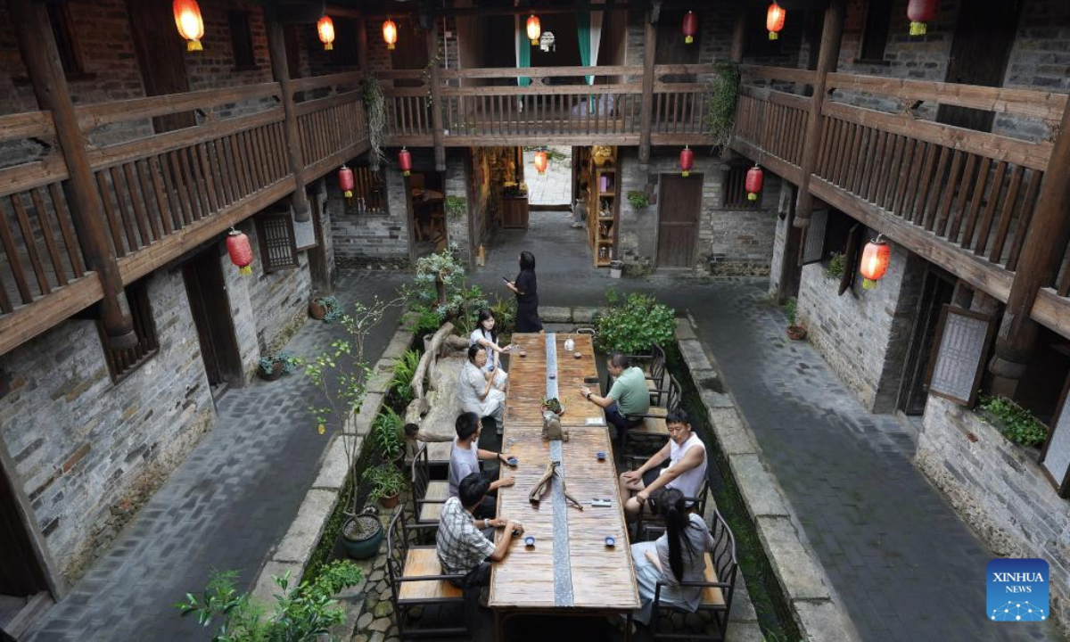 Tourists enjoy themselves inside a Hakka walled complex in Yangcun Town of Longnan, east China's Jiangxi Province, June 19, 2025. Longnan City in southern Jiangxi is home to 376 Hakka walled complexes, a special architectural type, accounting for more than 70 percent of all such structures in Gannan (southern Jiangxi Province). The whole structure of the building resembles a small fortified city, containing halls, storehouses and living areas. In recent years, Longnan City has launched a systematic preservation initiative, investing 150 million yuan (about 20.89 million U.S. dollars) to protect and restore these historical complexes. Up until now, the repair of 92 Hakka walled villages has been completed. These sites have transcended their roles as cultural relics, evolving into engines powering the city's cultural tourism and rural revitalization. In the first four months of this year, Longnan received 3.33 million tourists. (Xinhua/Wan Xiang)