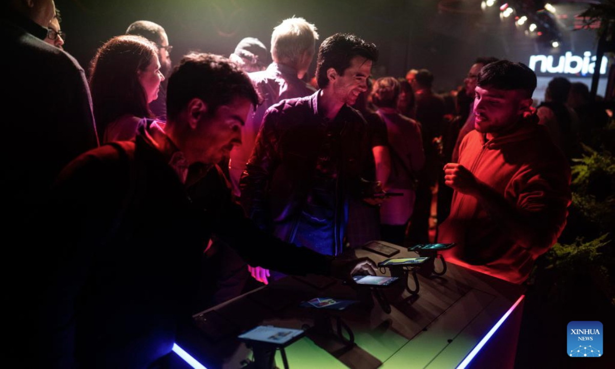 People try out Nubia smartphones in Buenos Aires, Argentina, on July 15, 2025. Chinese tech company ZTE held a product launch event in Buenos Aires on Tuesday, unveiling 10 new Nubia-branded devices, including smartphones. According to the company, all the new products are assembled in Río Grande, Tierra del Fuego Province, and became available nationwide in Argentina starting July 16. (Photo by Martin Zabala/Xinhua)