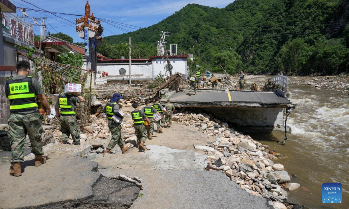 Rescuers deliver relief supplies on foot to road-blocked villages in Fengjiayu Town, Miyun District of Beijing, capital of China, July 30, 2025. Due to continuous heavy rainfall in recent days, hundreds of villages in multiple districts of Beijing have been affected. In some villages of Fengjiayu Town, Miyun District, the roads have not yet been restored. Relevant departments have organized multiple rescue forces including firefighters and militiamen to transport relief supplies on foot to the villages to ensure the living needs of the affected villagers. (Xinhua/Ju Huanzong)