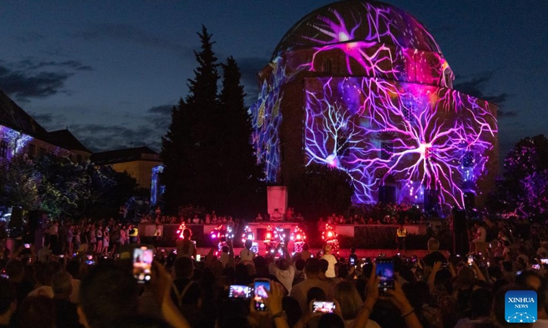 People enjoy a light performance during the Zsolnay Light Festival held in downtown Pecs, Hungary on July 4, 2025. (Photo: Xinhua)