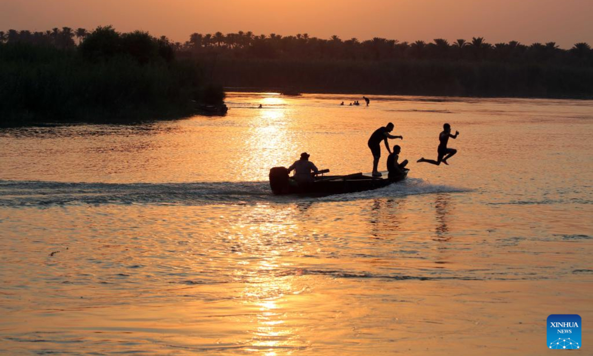 People enjoy swimming in the Tigris River in Baghdad, Iraq at sunset time on July 11, 2025. (Xinhua/Khalil Dawood)