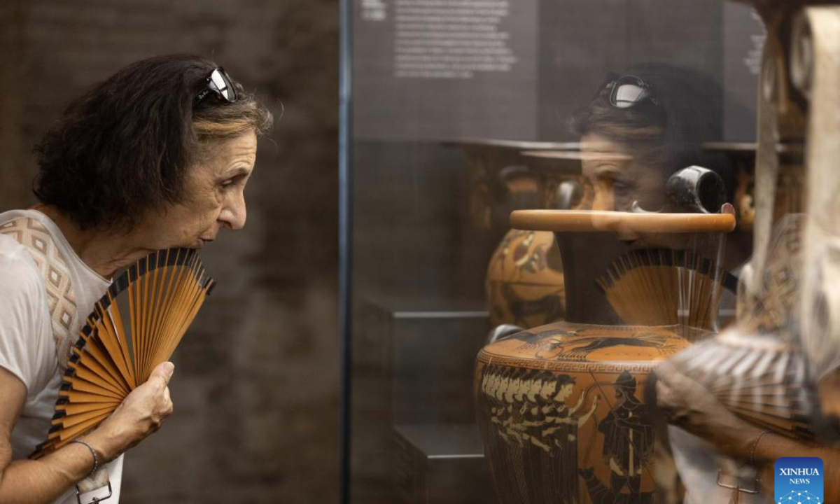 A visitor looks at a set of Attic black-figure amphora at the Museum of Rescued Art in Rome, Italy, July 24, 2025. The Museum of Rescued Art, part of the National Roman Museum network, reopened in June, showcasing over a hundred lost Italian antiquities recovered over the past three years by Italy's renowned art protection unit. (Xinhua/Li Jing)