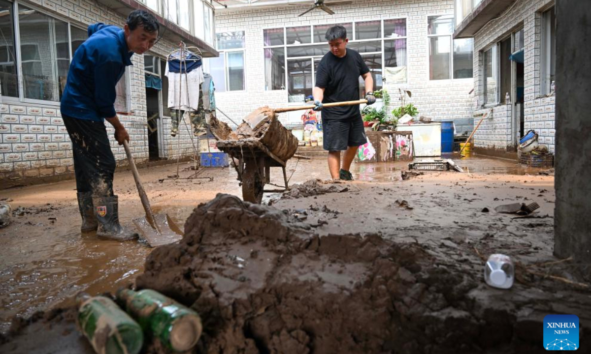 Villagers clean up silt in Liudaogou Village in Liudaohe Town, Xinglong County of north China's Hebei Province, Aug. 1, 2025. Affected by heavy rainfall, some roads and houses were damaged in several villages in Liudaohe Town. In recent days, local authorities have actively organized efforts to carry out relief operations to restore roads, power supply, and communication facilities, along with environmental disinfection measures. (Photo by Wang Liqun/Xinhua)