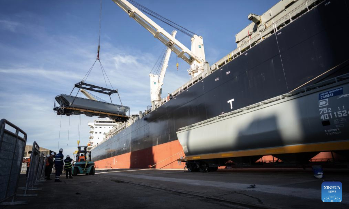 Workers unload a Chinese-made meter-gauge railway grain wagon at a port in Buenos Aires, Argentina, July 30, 2025. A total of 90 Chinese-made meter-gauge railway grain wagons arrived here on Tuesday, which will all be put into an Argentina's railway network to undertake soybean and corn transportation. (Photo by Martin Zabala/Xinhua)