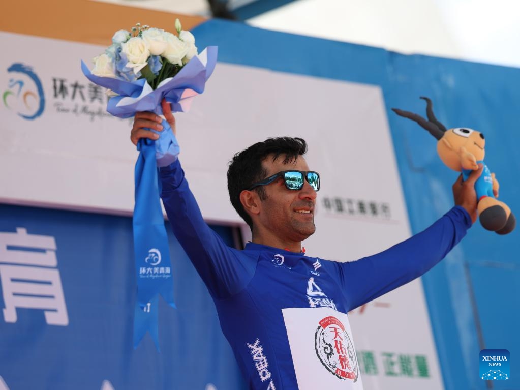 Hasan Seyfollahifard of Tianyoude Hotel Cycling Team celebrates in the blue jersey on the podium after Stage 1 of the Tour of Magnificent Qinghai international road cycling race in Xining, northwest China's Qinghai Province, July 6, 2025. (Photo: Xinhua)