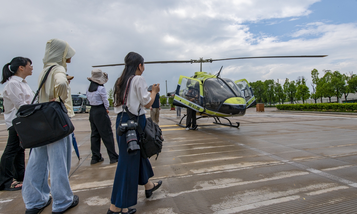 Local residents watch as the maiden flight of the 