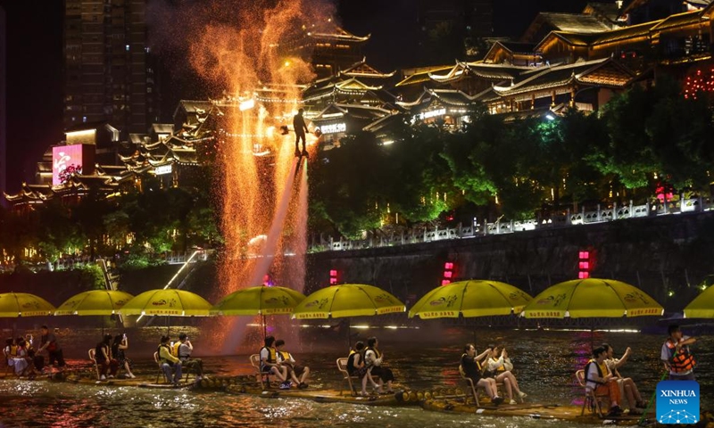 A folk artist performs on the Gongshui River in Xuan'en County, Enshi Tujia and Miao Autonomous Prefecture, central China's Hubei Province, July 9, 2025. In recent years, Xuan'en County of central China's Hubei Province has promoted nighttime tourism around the Gongshui River, which runs through the county. Activities and shows ranging from bamboo raft rides to molten iron fireworks attract visitors to enjoy the charm of the county under the lights. (Photo: Xinhua)