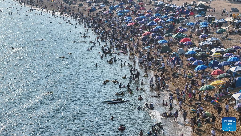 An aerial drone photo taken on July 10, 2025 shows tourists on the beach of Fujiazhuang Park in Dalian, northeast China's Liaoning Province. Dalian has been experiencing continuous high temperatures in recent days. The beach of Fujiazhuang Park in Dalian attracted a large number of tourists to cool off. (Photo: Xinhua)