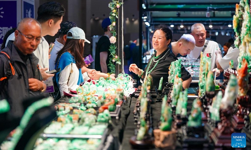 An exhibitor (3rd R) sells jade articles at the 2025 China Kunming International Stone Expo in Kunming, southwest China's Yunnan Province, on July 10, 2025. The 2025 China Kunming International Stone Expo opened in Kunming Thursday. The 5-day expo covers an area of about 50,000 square meters, gathering over 100 domestic and foreign business associations and exhibition groups. (Photo: Xinhua)