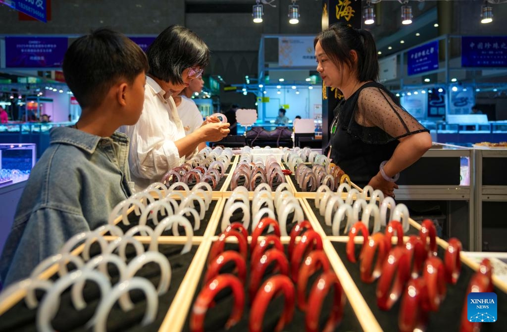 A customer (2nd L) selects jade bracelets at the 2025 China Kunming International Stone Expo in Kunming, southwest China's Yunnan Province, on July 10, 2025. The 2025 China Kunming International Stone Expo opened in Kunming Thursday. The 5-day expo covers an area of about 50,000 square meters, gathering over 100 domestic and foreign business associations and exhibition groups. (Photo: Xinhua)