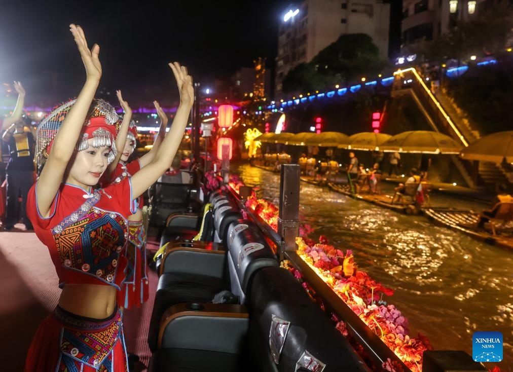 Folk artists perform on a sightseeing boat on the Gongshui River in Xuan'en County, Enshi Tujia and Miao Autonomous Prefecture, central China's Hubei Province, July 9, 2025. In recent years, Xuan'en County of central China's Hubei Province has promoted nighttime tourism around the Gongshui River, which runs through the county. Activities and shows ranging from bamboo raft rides to molten iron fireworks attract visitors to enjoy the charm of the county under the lights. (Photo: Xinhua)