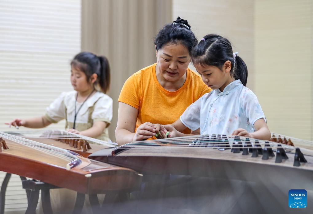 A kid learns to play Guzheng, a traditional Chinese musical instrument, under the guidance of a teacher at a culture center in Jurong City, east China's Jiangsu Province, July 12, 2025. Children across the country are enriching their summer vacations through colorful activities. (Photo: Xinhua)