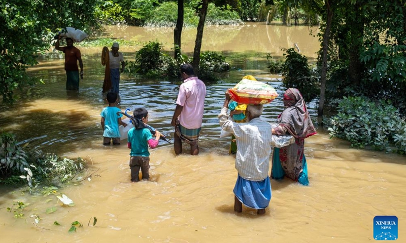 People wade through floodwater on a road in Feni, Bangladesh, July 11, 2025. As the monsoon sets in and rainfall continues, flooding has occurred in parts of Feni. (Photo: Xinhua)