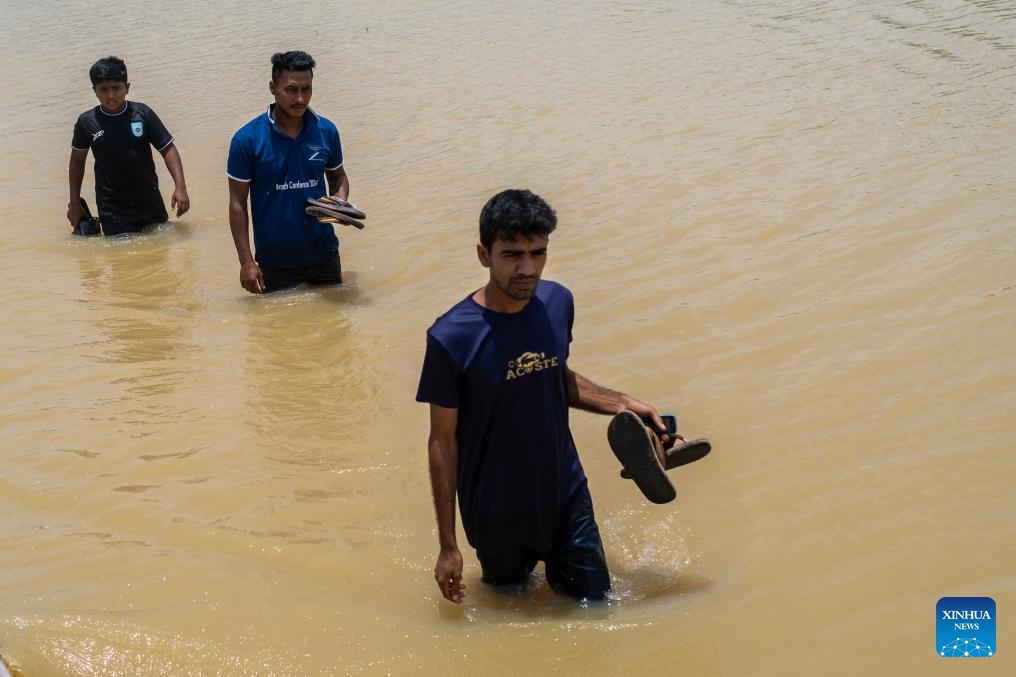 People wade through floodwater on a road in Feni, Bangladesh, July 11, 2025. As the monsoon sets in and rainfall continues, flooding has occurred in parts of Feni. (Photo: Xinhua)