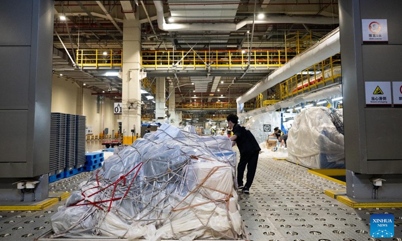 A worker sorts out goods at the cargo transfer center of Ezhou Huahu International Airport in Ezhou, central China's Hubei Province, July 11, 2025. Brightly lit during the night, Ezhou Huahu International Airport, China's first cargo-focused airport, is kept awake handling cargo from home and abroad. Starting operation in July 2022, the airport, owning a 750,000-square meter cargo transfer center with parcel sorting lines adding up to 52 kilometers, is now running 59 domestic cargo routes in addition to 45 international routes. (Photo: Xinhua)