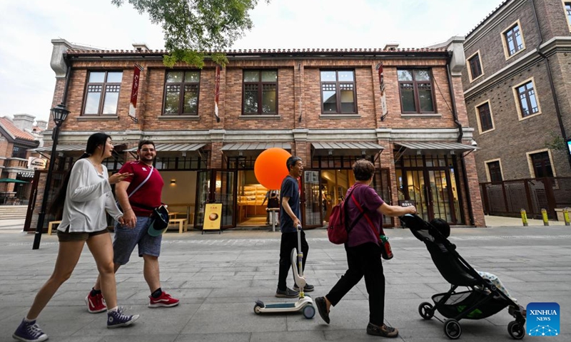 Tourists enjoy leisure time at the Wudadao historical urban area in north China's Tianjin, July 9, 2025. The Minyuan 1920 Block, a recently completed infrastructure enhancement project, has officially opened to the public. The project transforms sections of Hunan Road and Luoyang Avenue into a pedestrian zone and connects Minyuan Square and Wudadao Park, injecting vitality into the century-old historical area. (Photo: Xinhua)