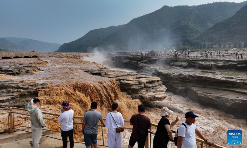 A drone photo shows people visiting the Hukou Waterfall on the Yellow River in Yichuan County, northwest China's Shaanxi provinces, July 12, 2025. The waterfall is located on the border area between north China's Shanxi and northwest China's Shaanxi provinces. (Photo: Xinhua)