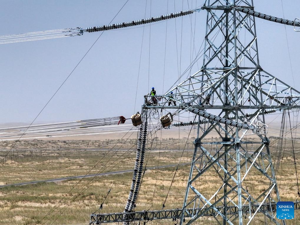 Staff members work on the final section of the 750-kilovolt (kV) loop in Minfeng County of Hotan Prefecture, northwest China's Xinjiang Uygur Autonomous Region, July 13, 2025. China has finished construction of a 4,197-km extra-high voltage power transmission loop around the Tarim Basin, home to the country's largest desert, marking a major infrastructure milestone in southern Xinjiang Uygur Autonomous Region in northwest China. (Photo: Xinhua)
