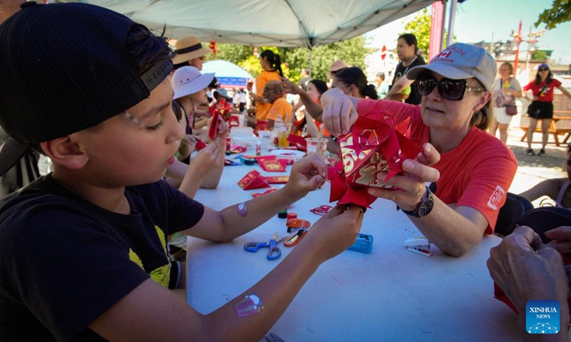 People make paper lanterns during the 23rd Vancouver Chinatown Festival in Vancouver, British Columbia, Canada, July 13, 2025. The annual cultural festival was held in Vancouver's historic Chinatown, celebrating Chinese heritage and promoting multiculturalism through performances, food stalls, exhibits, and family-friendly activities. (Photo: Xinhua)