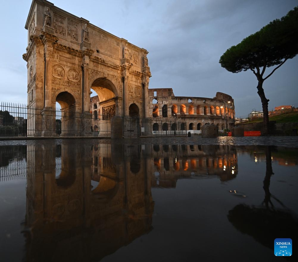 This photo taken on July 13, 2025 shows the Arch of Constantine and the Colosseum and their reflections in a puddle after rain in Rome, Italy. (Photo: Xinhua)