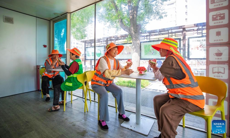 Sanitation workers have watermelon as a summer refreshment at a devoted lounge in Xinghua City of east China's Jiangsu City, July 13, 2025. A heatwave is sweeping multiple regions in China, prompting authorities to roll out measures to ensure job safety and stable production. (Photo: Xinhua)