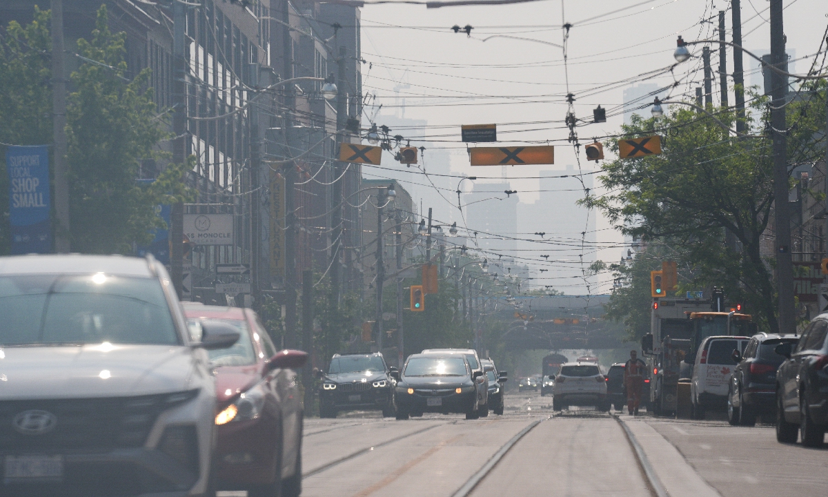The hazy Toronto skyline is seen as smoke from northern Ontario wildfires creates haze in Toronto, Ontario on July 14, 2025. Environment Canada issued air quality warnings for Toronto stating that smoke from forest fires over northern Ontario and Prairies is causing poor air quality and reduced visibilities. Photo: VCG