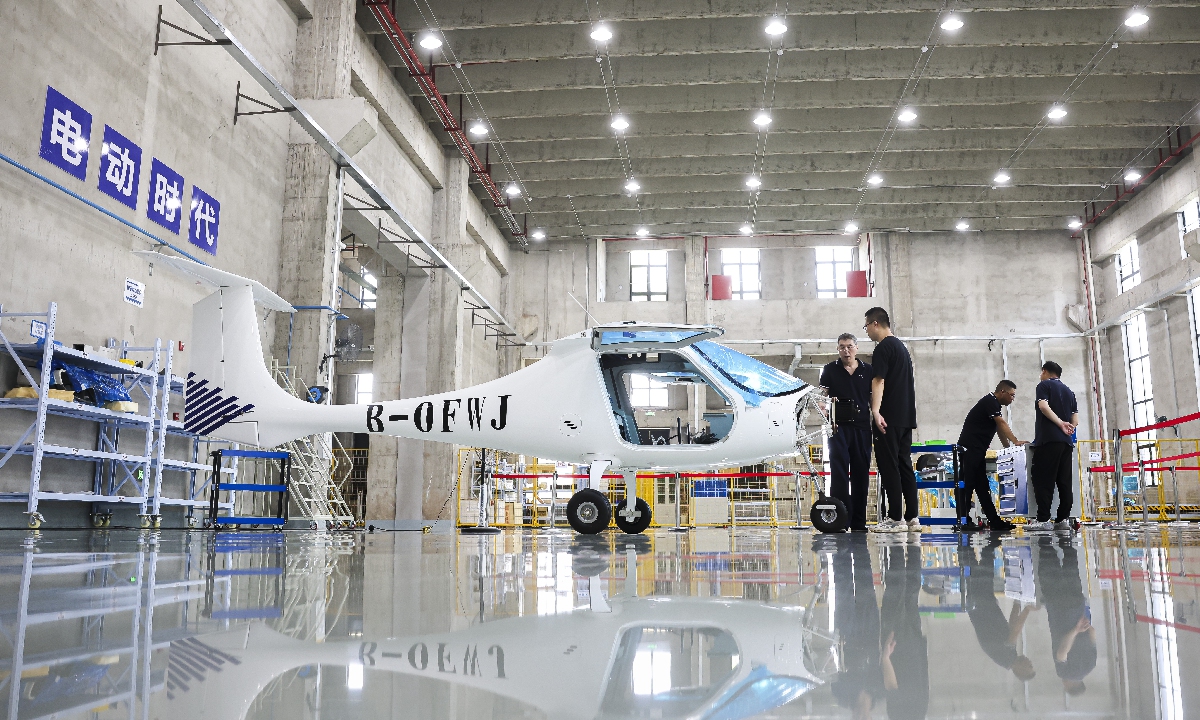 Workers assemble a two-seat light sport aircraft at a workshop in Jiaxing, East China's Zhejiang Province on July 16, 2025. With a range of up to 280 kilometers, the aircraft, featuring low noise, zero emissions, easy maintenance, high safety and low operating cost, has won strong market favor, with orders booked through next year. Photo: VCG