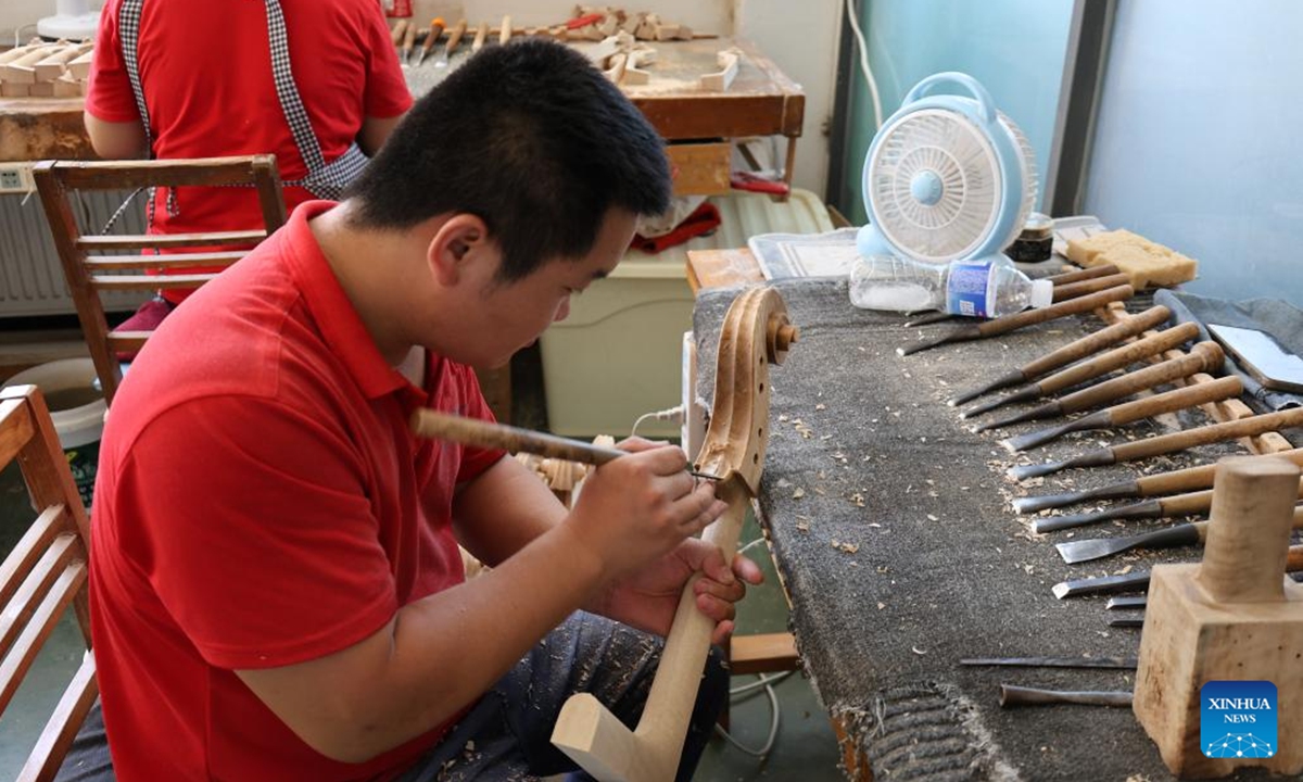 A worker works at a workshop in Queshan Violin Industrial Park, Queshan County of Zhumadian City, central China's Henan Province, July 24, 2025(Xinhua/Zhu Weixi)