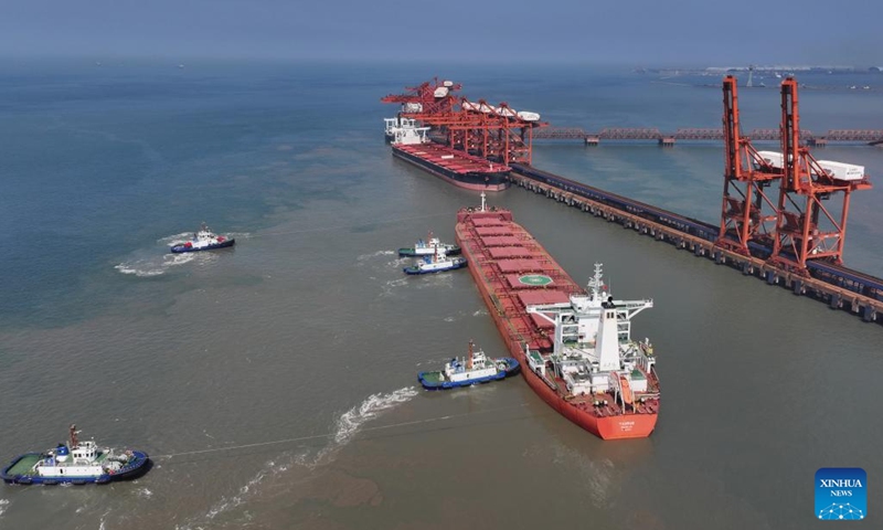 A drone photo taken on July 18, 2025 shows a cargo ship, assisted by tugboats, berthing at the ore terminal of Caofeidian Port Area in Tangshan Port in Tangshan, north China's Hebei Province. The cargo throughput at Tangshan Port reached 433.56 million tonnes in the first half of 2025, up 0.75 percent year on year, according to port authorities. (Photo: Xinhua)