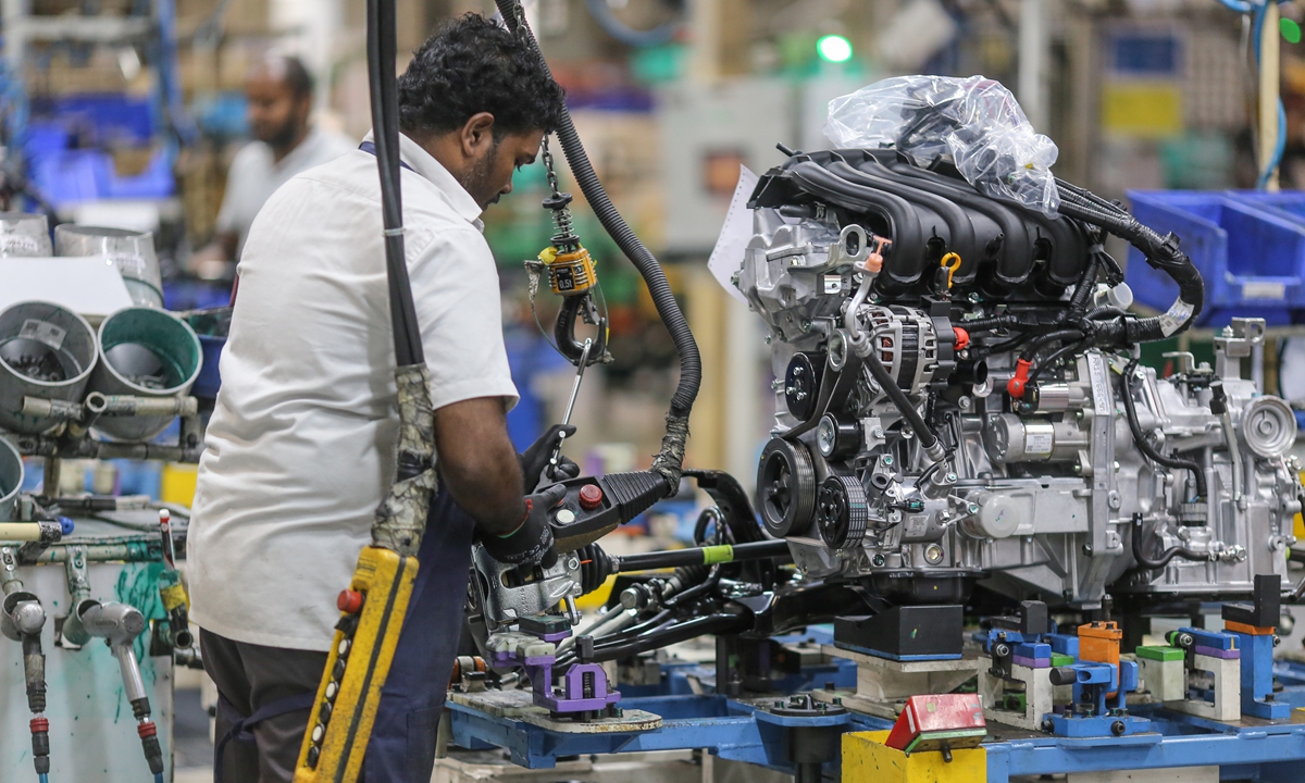 An employee works on an engine block on the assembly line at a manufacturing plant in Chennai, India. Filephoto: VCG