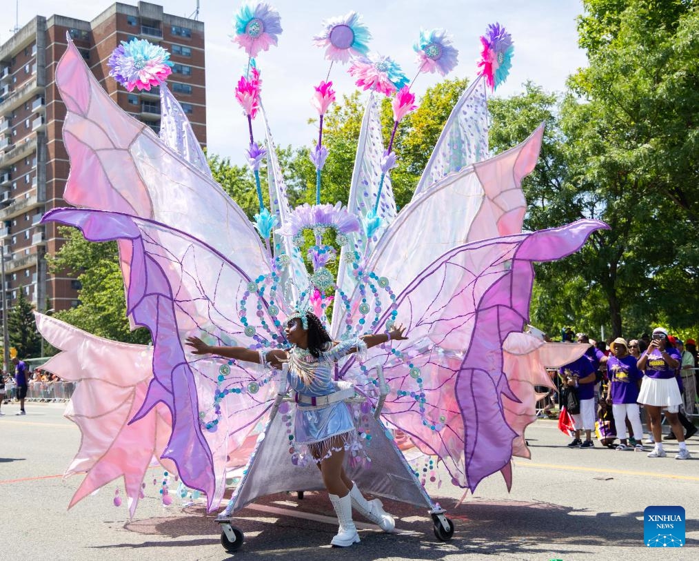 A dressed-up girl dances with her float during the Junior Carnival Parade of the 2025 Toronto Caribbean Carnival in Toronto, Canada, on July 19, 2025. The annual event kicked off here on Saturday with thousands of young participants in vibrant costumes celebrating Caribbean culture with music and dance. (Photo: Xinhua)