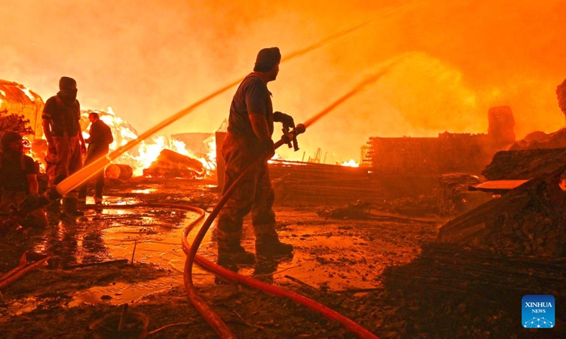 Firefighters attempt to put out a fire that engulfed a wood warehouse in Jahra Governorate, Kuwait, on July 18, 2025. (Photo: Xinhua)