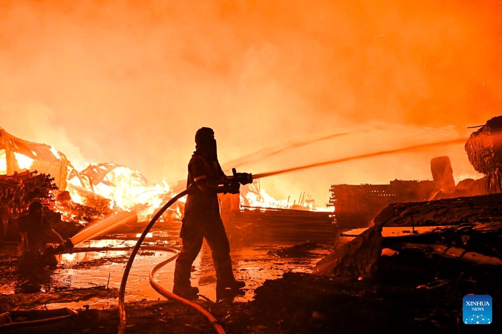 Firefighters attempt to put out a fire that engulfed a wood warehouse in Jahra Governorate, Kuwait, on July 18, 2025. (Photo: Xinhua)