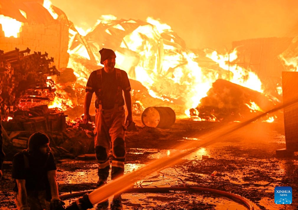 Firefighters attempt to put out a fire that engulfed a wood warehouse in Jahra Governorate, Kuwait, on July 18, 2025. (Photo: Xinhua)