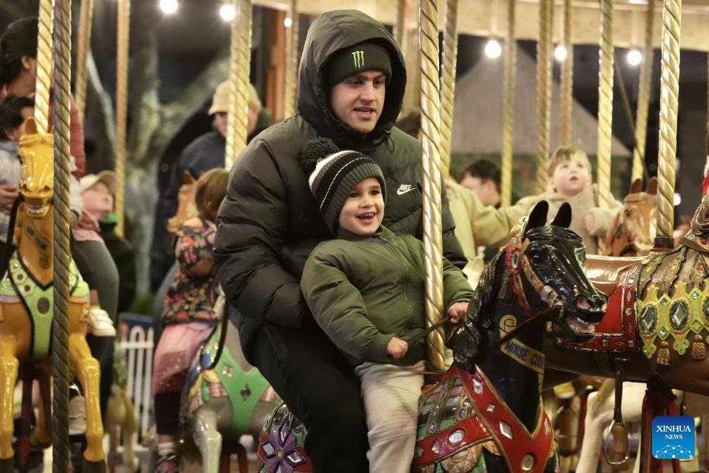 Children enjoy a carousel ride with parents during the Winter in the City event in Canberra, Australia, on July 19, 2025. Wrapped up here on Saturday, the two-week event enlivened Canberra's city center with nightly fire shows, acrobatic performances and interactive musical theatre, creating a vibrant winter festive atmosphere. Besides the entertainment, over 30 food stalls representing cuisines from around the world offered visitors a diverse culinary experience. (Photo: Xinhua)