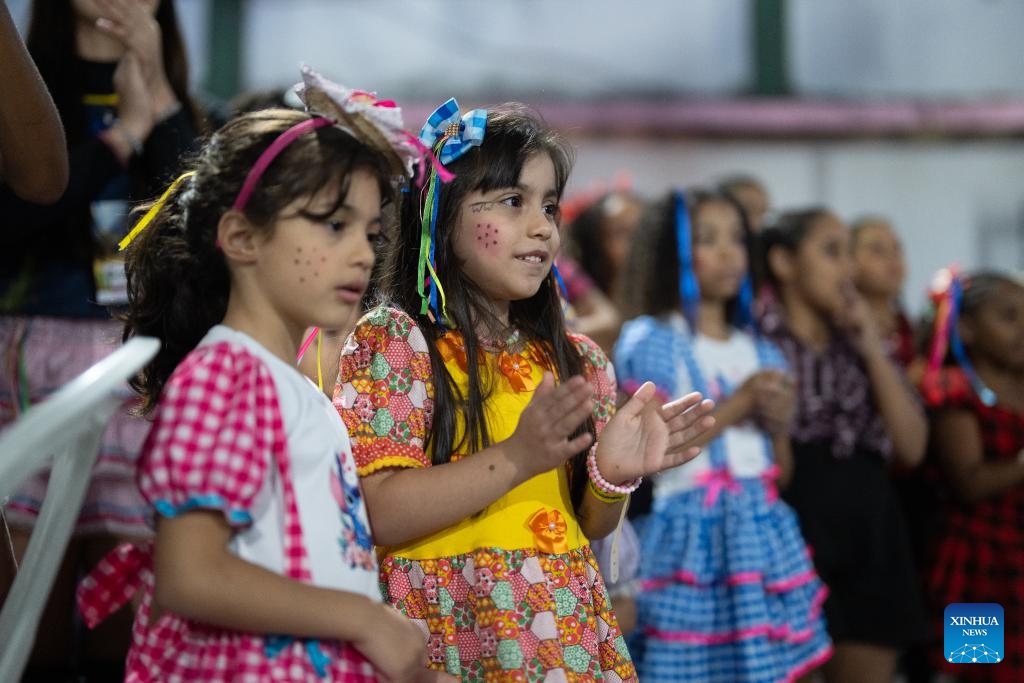Children watch performances during a celebration of harvest in the Manguinhos community in Rio de Janeiro, Brazil, July 19, 2025. (Photo: Xinhua)