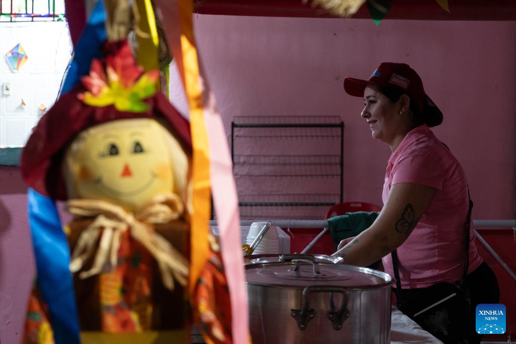 A woman prepares food during a celebration of harvest in the Manguinhos community in Rio de Janeiro, Brazil, July 19, 2025. (Photo: Xinhua)