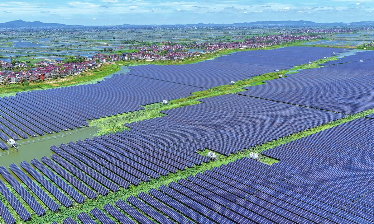 Workers install solar panels at a 