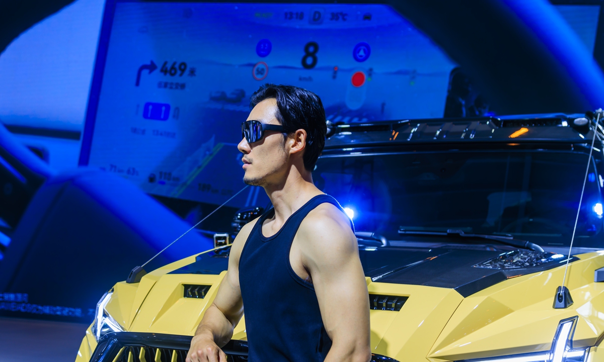 A model stands next to a car displayed at the ongoing Kunming International Auto Show in Kunming, Southwest China's Yunnan Province on July 24, 2025. The exhibition brings together more than 100 auto brands, covering fuel-fired vehicles, hybrid vehicles, and pure electric vehicles, as well as many innovative products. Photo: VCG