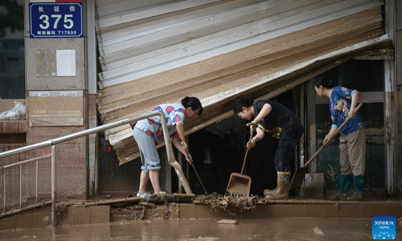 People do cleanup work after flood in Wuqi County of Yan'an City in northwest China's Shaanxi Province, July 26, 2025. Heavy rainfall has affected Wuqi County since Thursday, resulting in severe flooding. Local authorities have activated Level-III emergency response for flood prevention and control, with dedicated resources for disaster relief and restoration. Most major streets in Wuqi have been cleared, water supply largely resumed, and no reports of casualties have been received as of Saturday, according to the county authority in charge of flood response. (Photo: Xinhua)